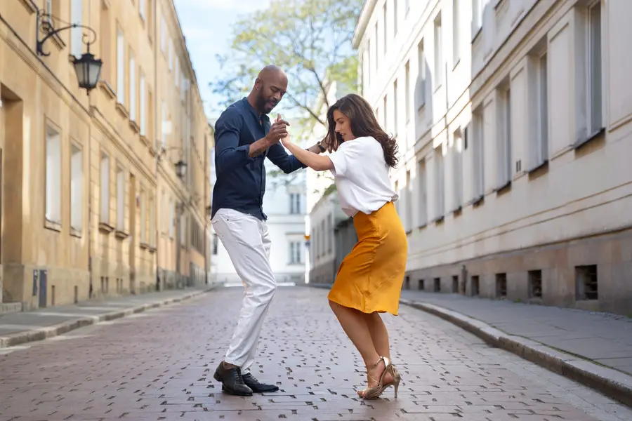 Couple débutant apprenant des pas de salsa dans une salle lumineuse
