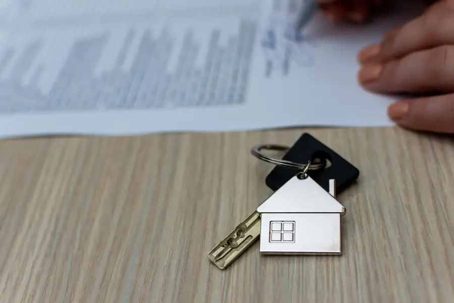 Locataire relisant attentivement un bail d’appartement avec calculatrice et dossiers