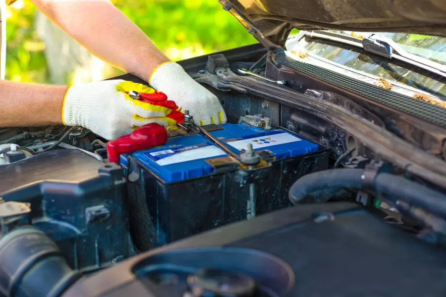Batterie automobile 12 volts contrôlée avec un testeur dans un garage