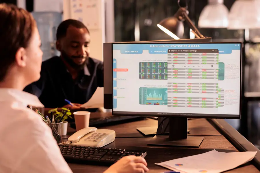 Dirigeante comparant des tableaux financiers sur ordinateur dans un bureau