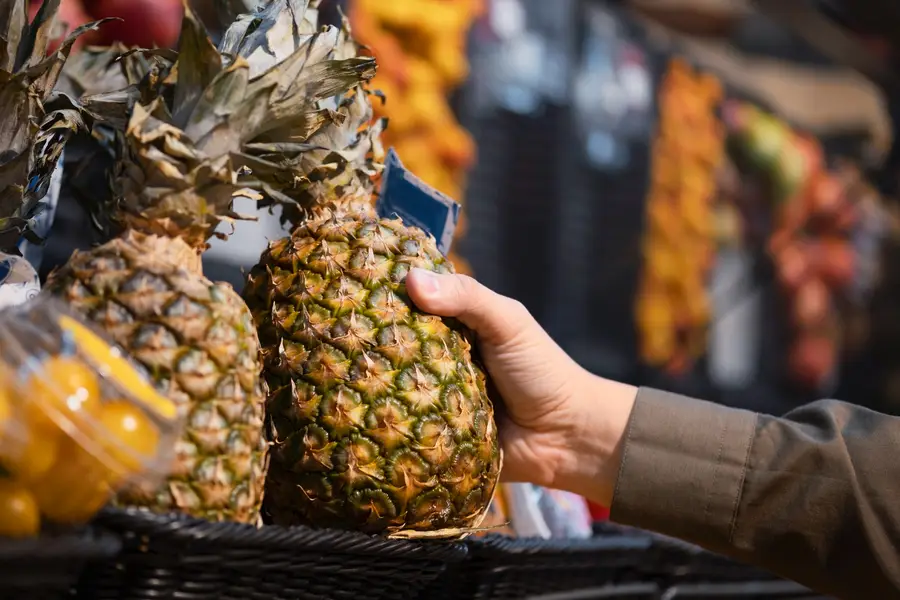 Ananas entier mûr posé sur un étal de marché français