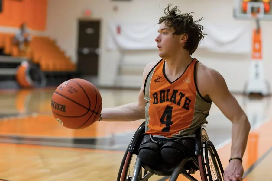 Joueur de basket fauteuil manœuvrant sur un terrain intérieur