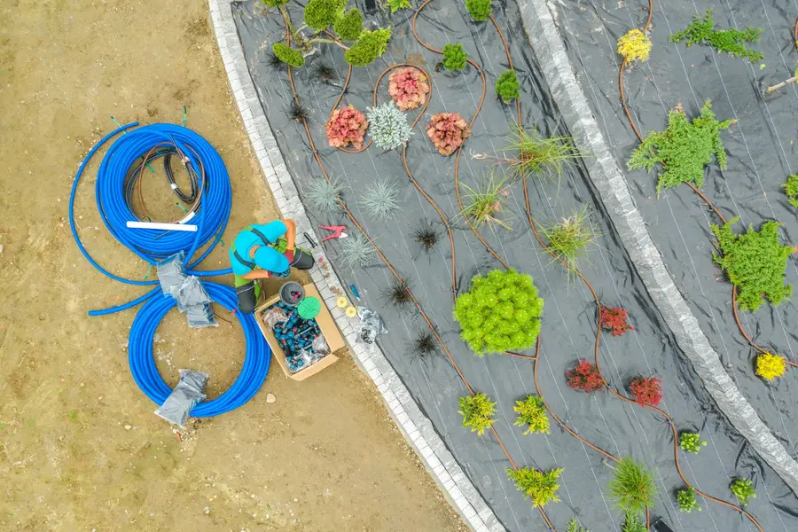Technicien inspectant une installation d’assainissement individuel dans un jardin français