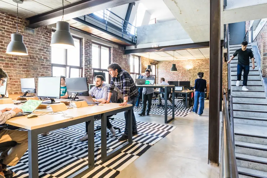Équipe travaillant dans un espace de coworking lumineux avec bureaux partagés