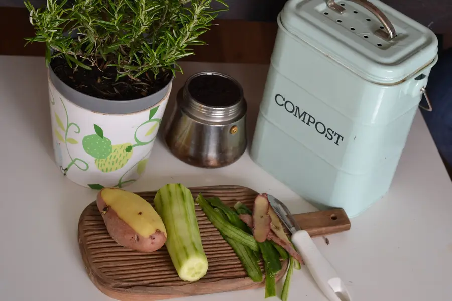 Composteur de jardin ouvert avec feuilles, épluchures et compost mûr
