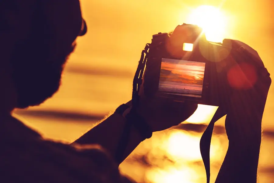 Photographe sur trépied capturant un parc en lumière infrarouge