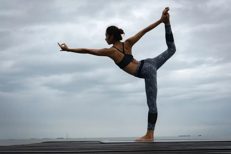 Personne pratiquant une posture de yoga douce près d’un mur