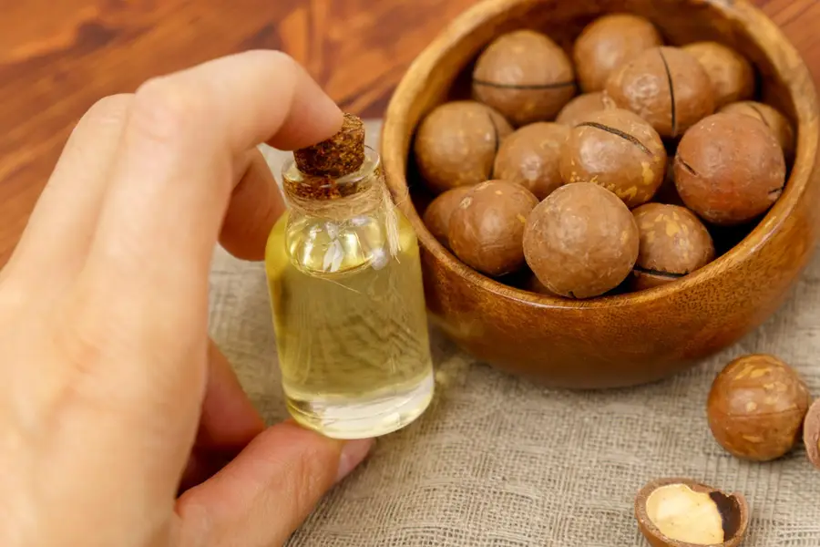 Flacon d’huile d’argan et amandons sur une table en bois