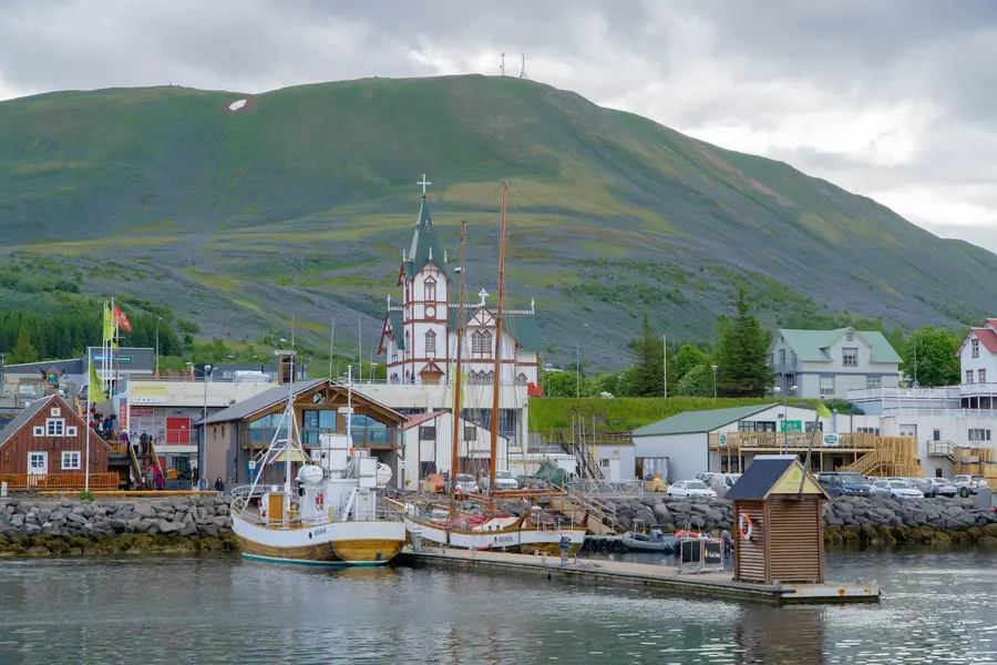 Port coloré de Seyðisfjörður entouré de montagnes islandaises brumeuses