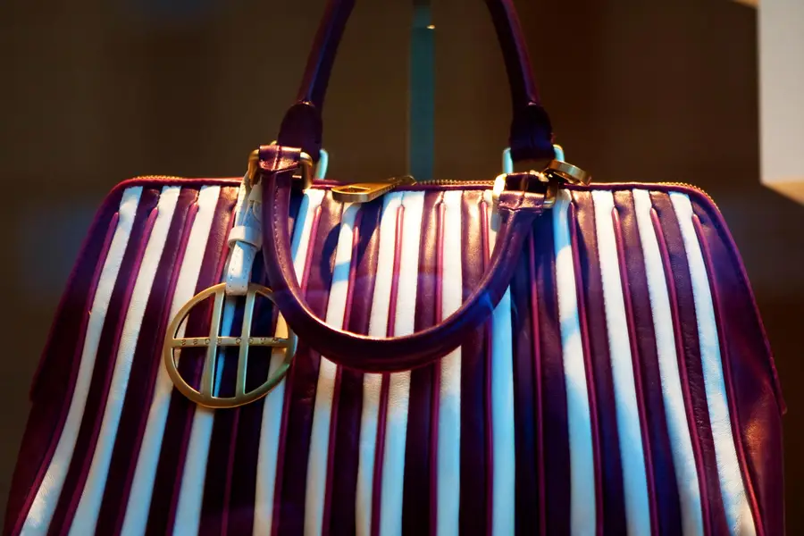 Sac matelassé noir près d’une malle de voyage vintage