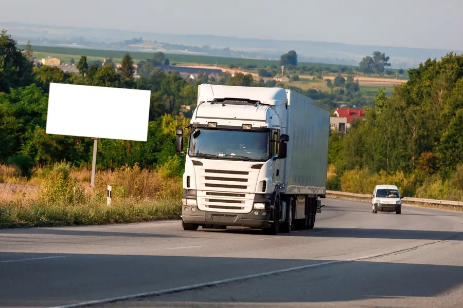 Grand camion de déménagement blanc stationné devant un immeuble français