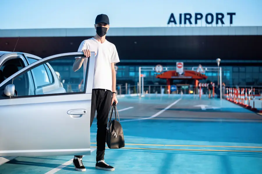 Voyageurs récupérant une voiture de location devant l’aéroport de Guadeloupe