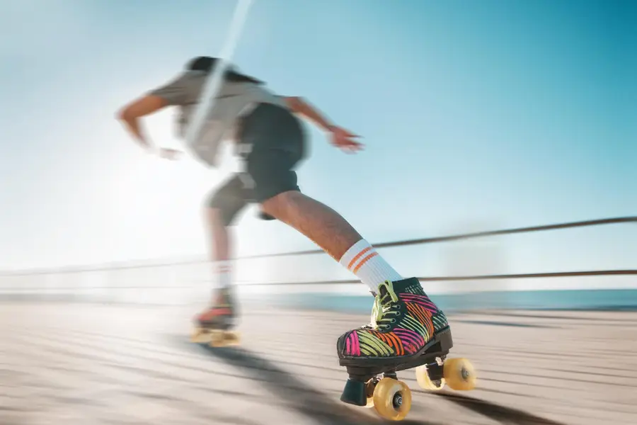 Adulte en patins en ligne équipé de protections sur voie verte