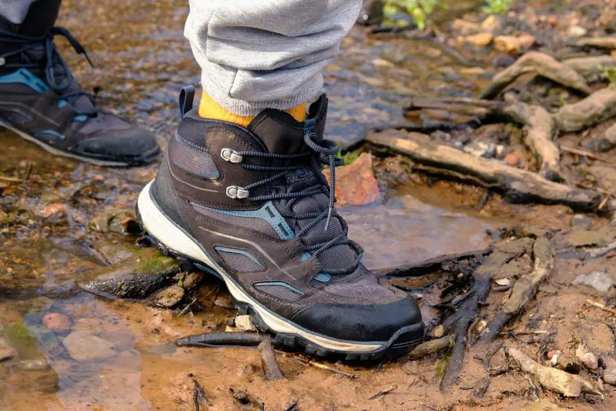 Randonneur portant des chaussures minimalistes sur un sentier forestier français sec