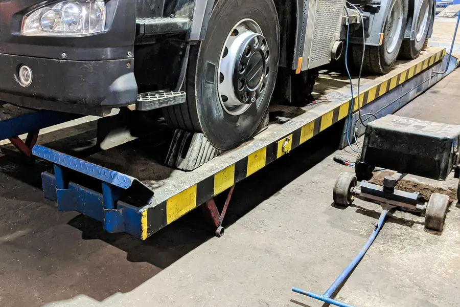 Technicien mesurant une bande transporteuse industrielle dans un atelier français