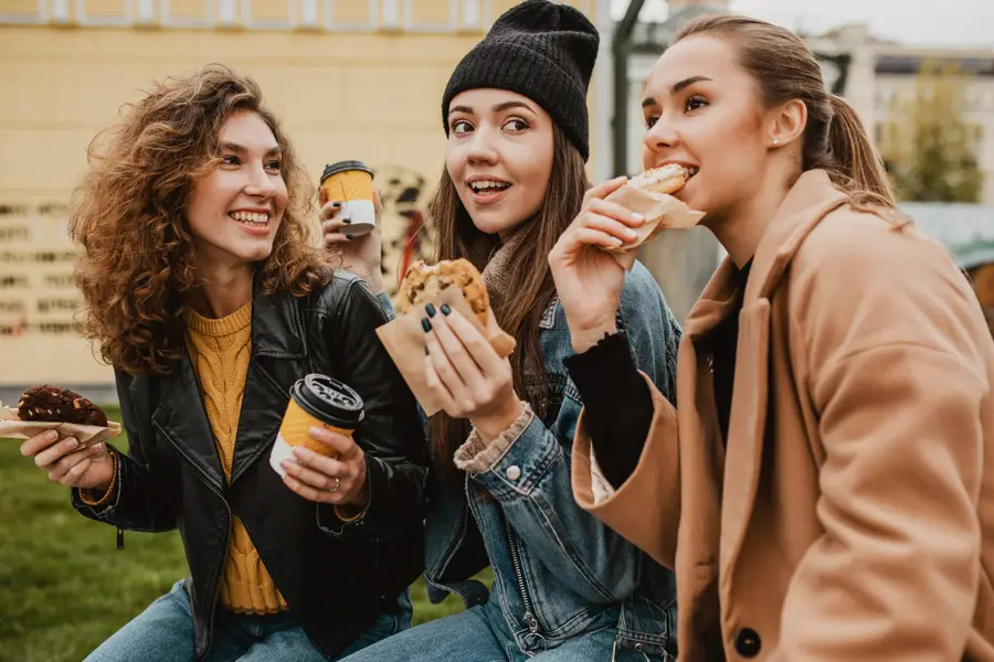 Foodtruck éclairé servant des plats chauds pendant une soirée d’hiver pluvieuse