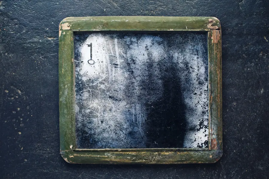 Vieux miroir encadré nettoyé délicatement avec une microfibre blanche
